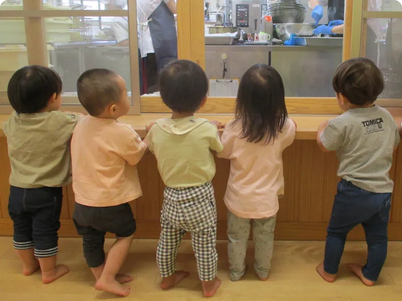 園児が芝生で遊んでいる画像