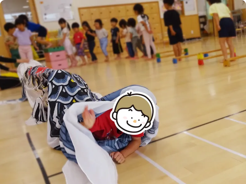 園児が芝生で遊んでいる画像